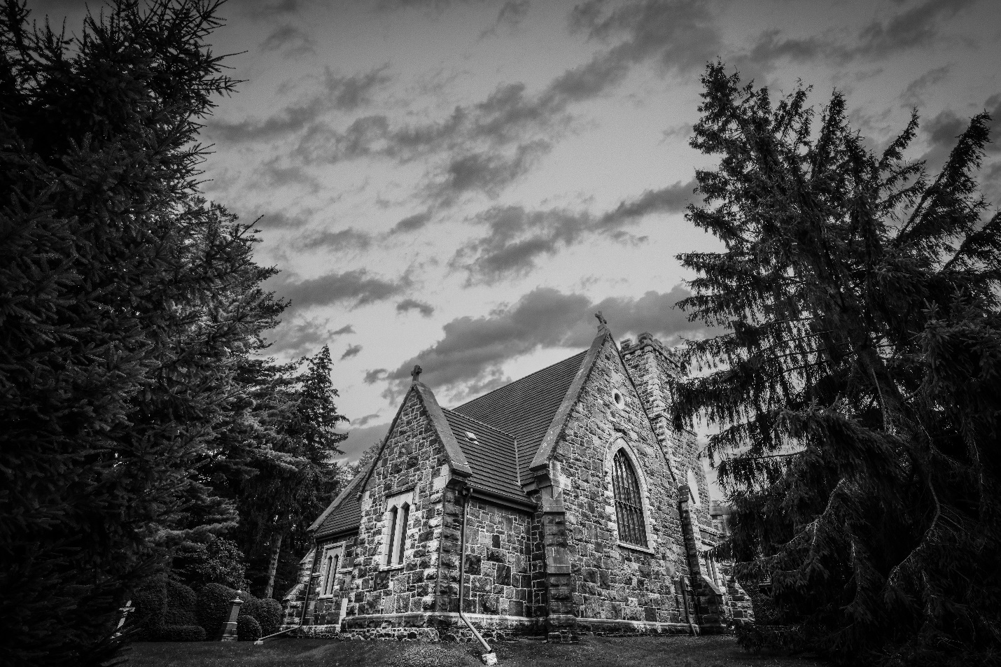 A stone building with trees in the background</p>
<p>Description automatically generated