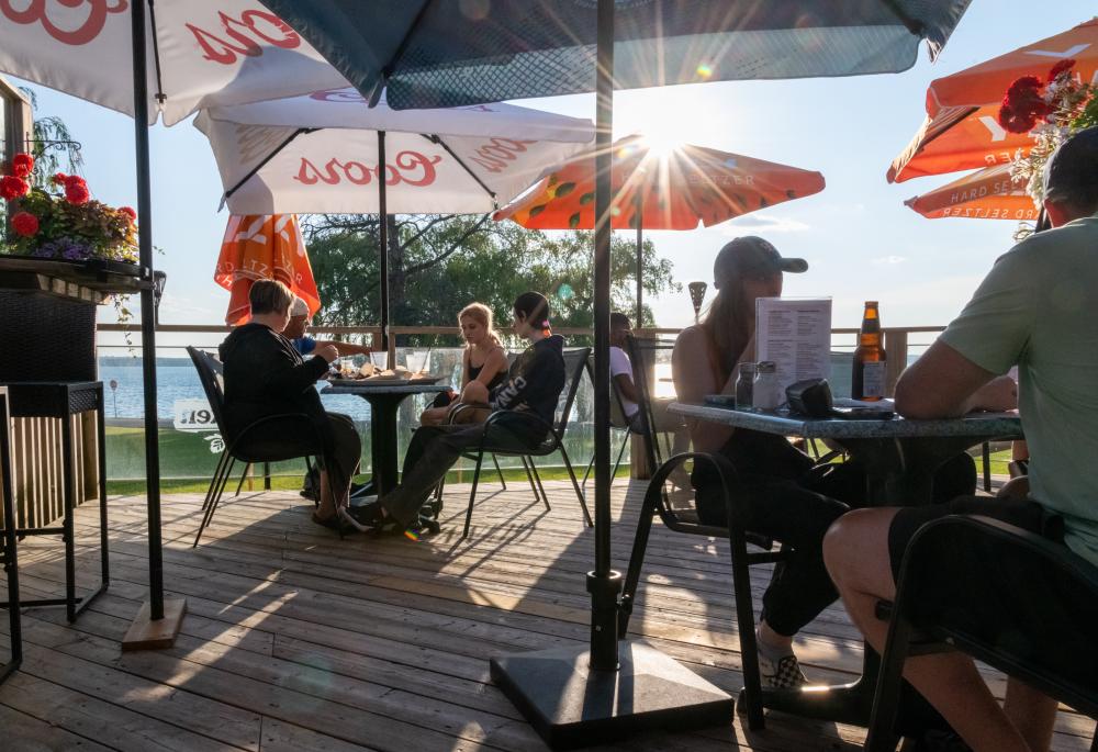 patrons enjoying a patio with lake in the background