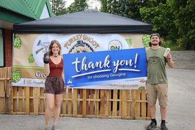 Owners of Turkey Shoot Brewing Company pose for a photo outside of beer garden