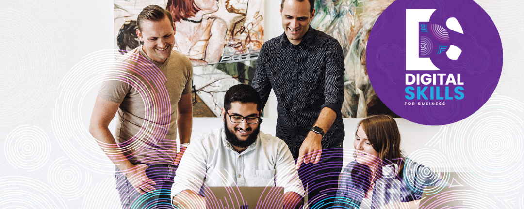 group of people looking at a computer with the words digital skills